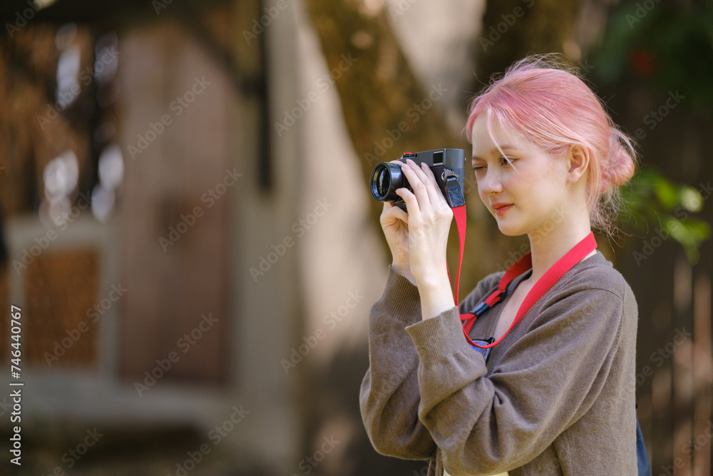 Beautiful woman with camera. Happy smiling woman taking photos of beautiful location.