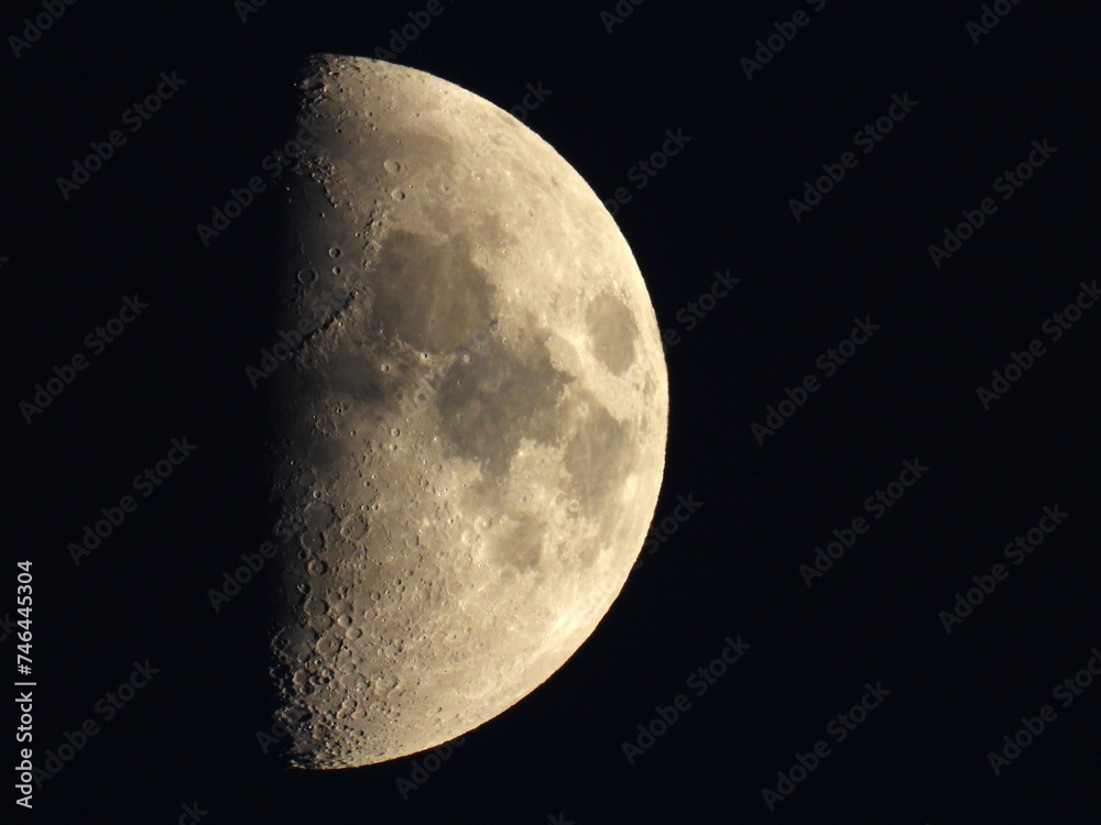 moon in the waxing half moon phase with clouds