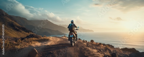 Back view of man riding a off-road motorcycle, going up to steep cliff. photo