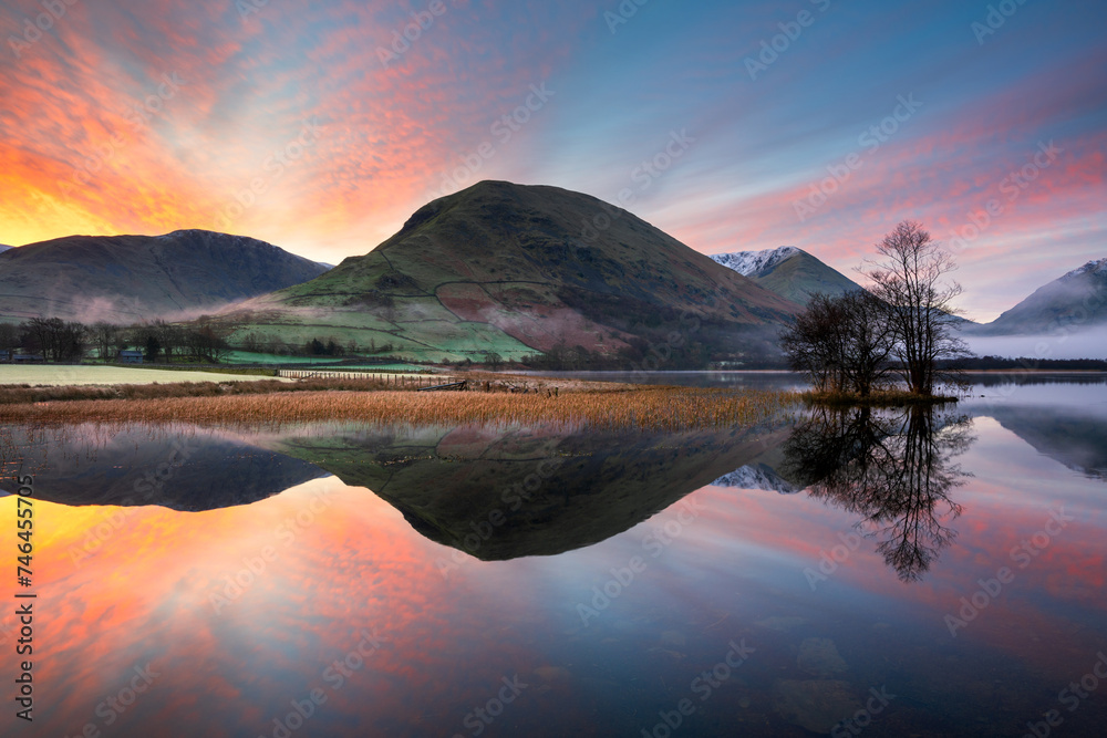 Obraz premium Beautiful sunrise with reflections in lake at Brothers Water on a calm morning in The Lake District, UK.