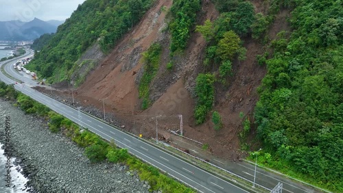 Mountain soil collapse in half of the highway. Landslides due to heavy rainfall. Rockslide over road. Dangerous Landslide, natural disaster led to roadblock. Climate change, warming, desertification photo