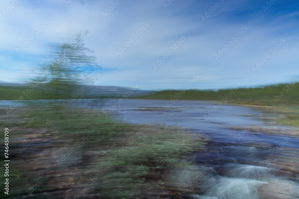 Obraz premium Intentional camera movement (ICM) of start of Siilaskoski rapids from lake Siilasjärvi in autumn, Kilpijärvi, Enontekiö, Lapland, Finland.