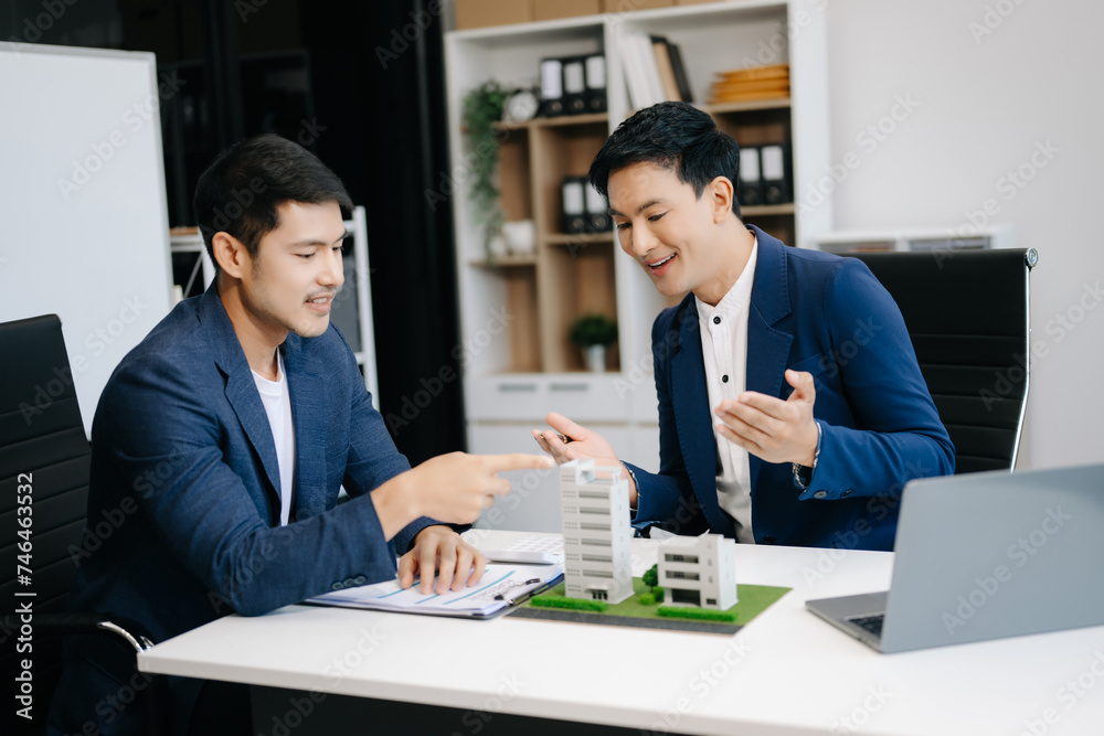 balancing the property sector The real estate agent is explaining the house style to see the house design and the purchase agreement. model house balancing the property sector The real estate agent is explaining the house style to see the house design and the purchase agreement. model house