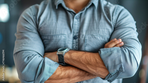 Young businessman wearing shirt standing with his arms folded  he is wearing a watch in his hand