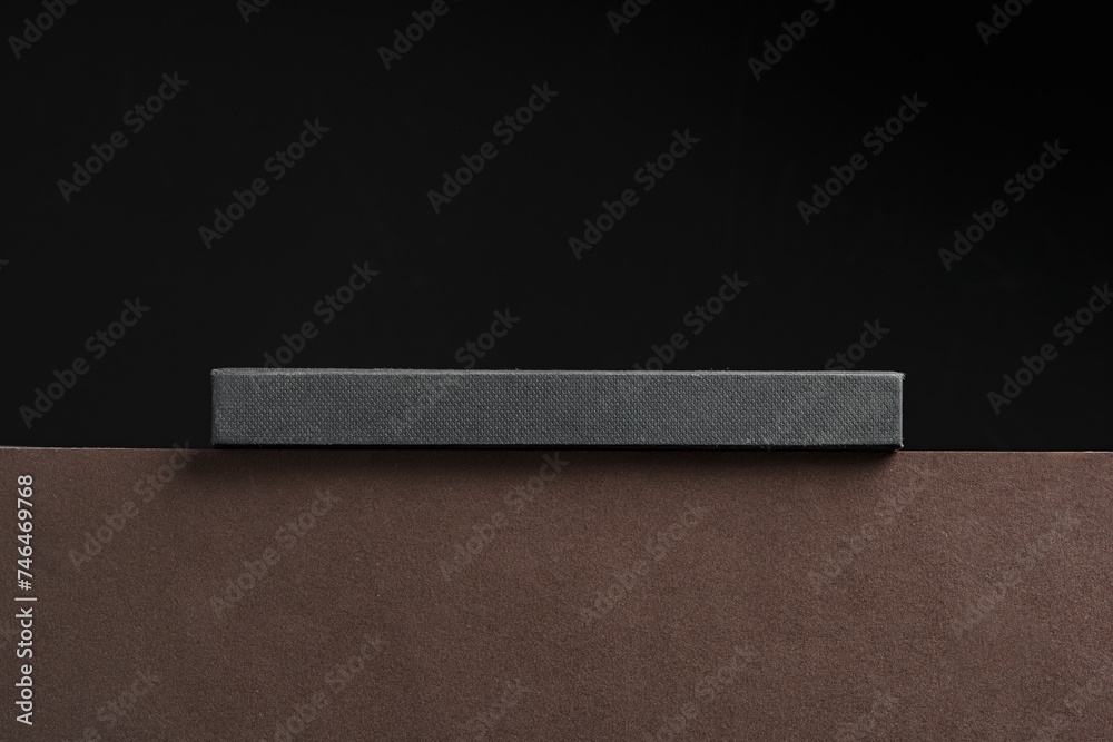 Black hardcover book or notepad mock up on black background Black hardcover book or notepad mock up on black background