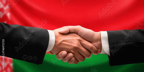 Businessman, diplomat in suits clasp hands for handshake over Belarus flag, agree on united success in trade, diplomacy, cooperation, negotiation, support, teamwork in commerce, gesture of greeting