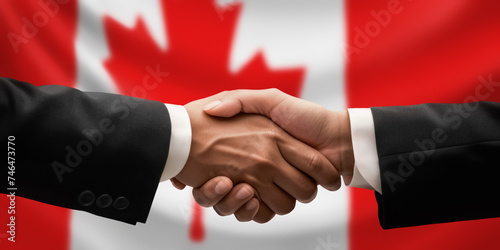 Businessman and diplomat in suits clasp hands for handshake over Canada flag, agree on united success in trade, diplomacy, cooperation, negotiation, support, teamwork in commerce, gesture of greeting