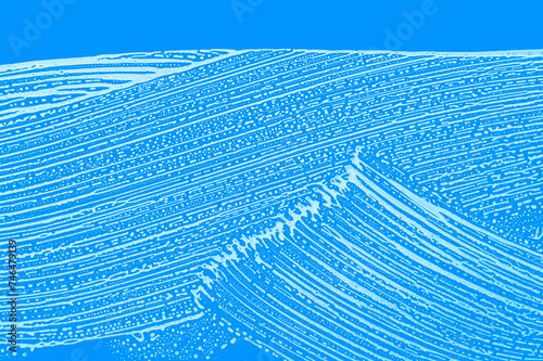 blue background with waves of white soap foam wipe marks on window glass