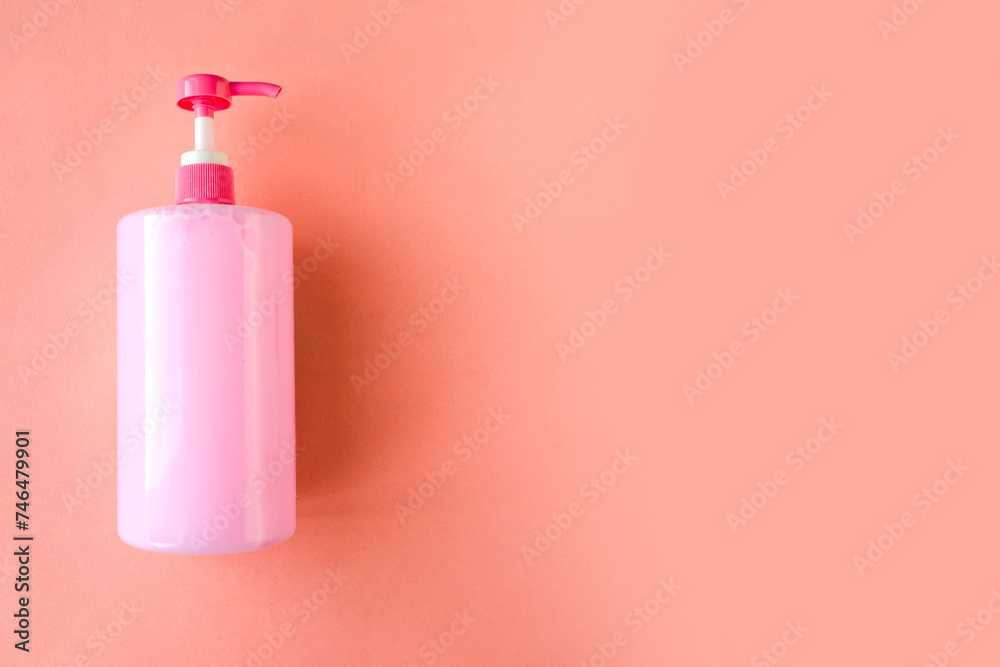 Bottle with pink dishwashing liquid on pink background. Minimal concept. Copy space for the text - obrazy, fototapety, plakaty 