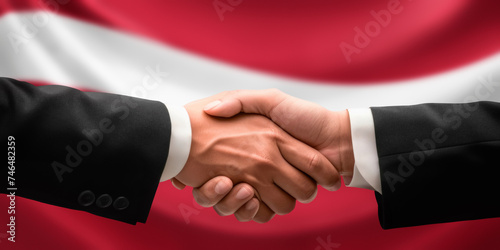 Businessman and diplomat in suits clasp hands for handshake over Latvia flag, agree on united success in trade, diplomacy, cooperation, negotiation, support, teamwork in commerce, gesture of greeting
