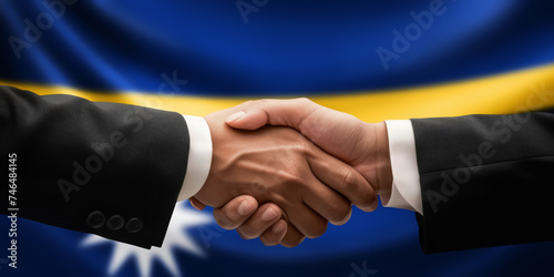 Businessman and diplomat in suits clasp hands for handshake over Nauru flag, agree on united success in trade, diplomacy, cooperation, negotiation, support, teamwork in commerce, gesture of greeting