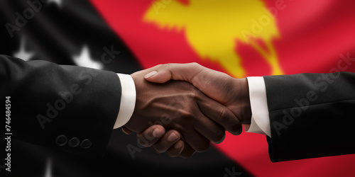 Businessman, diplomat in suits clasp hands for handshake over Papua New Guinea flag, agree on united success in trade, diplomacy, cooperation, negotiation, teamwork in commerce, gesture of greeting