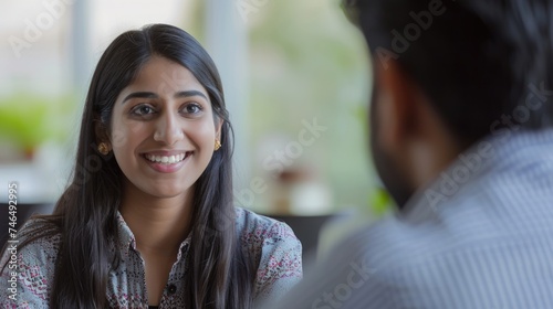 A smiling woman having a conversation with a man