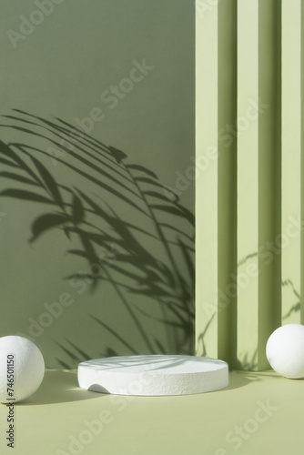 White round podium on an abstract green background with a shadow of palm leaves. A scene with a geometric background. Backdrop for the product presentation. Showcase  display case.