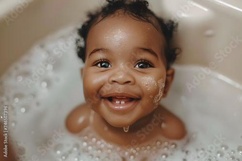 Close up portrait of cute African baby smiling enjoying a bubbly bath