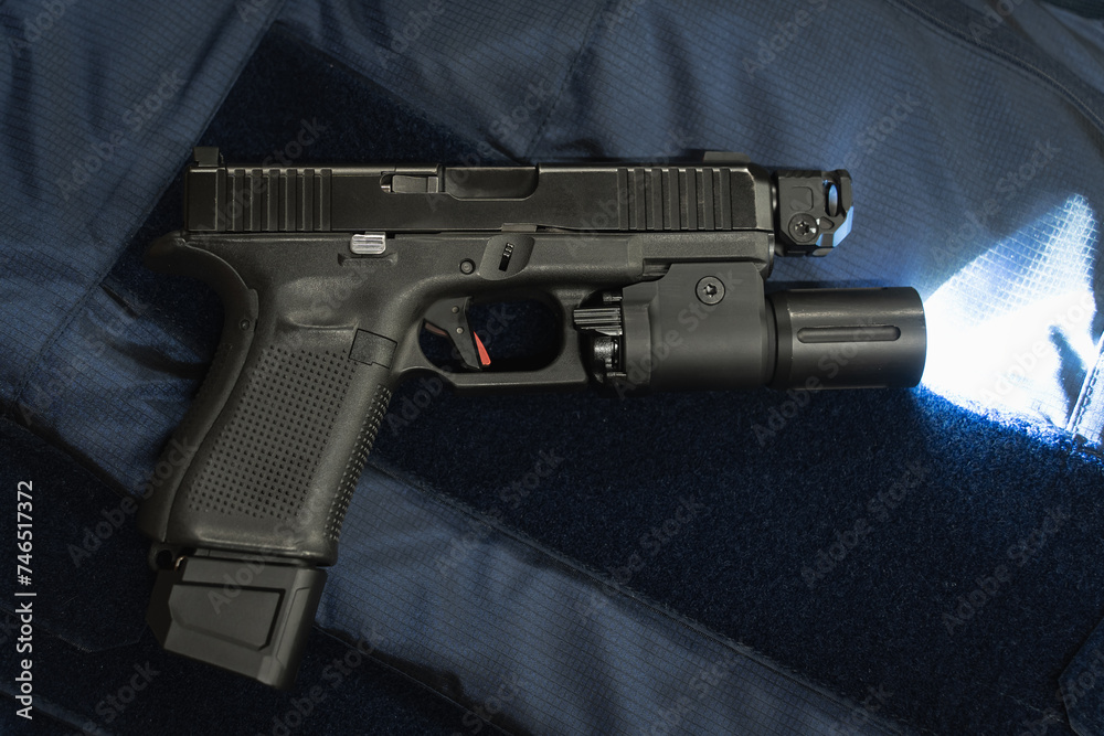 Tactical g19 pistol with a flashlight on a police vest.