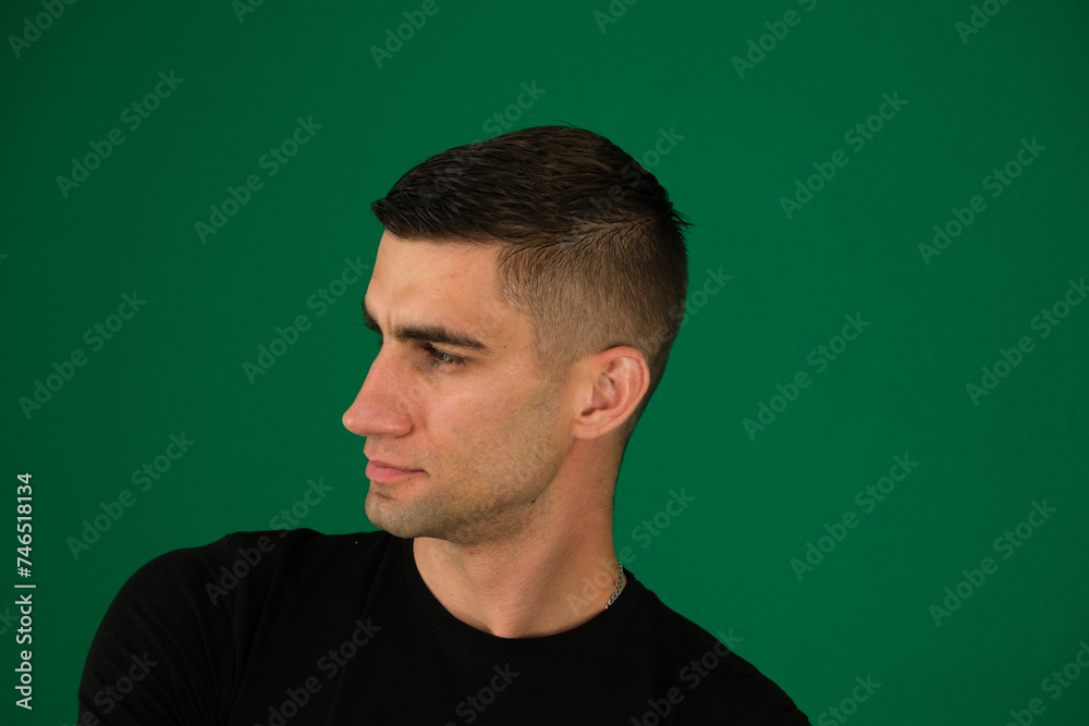 Close up profile view of young handsome man isolated against. emotions of a handsome man guy on a green background chromakey close-up dark hair young man Close up profile view of young handsome man isolated against. emotions of a handsome man guy on a green background chromakey close-up dark hair young man