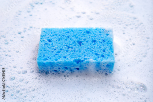 Cleaning sponge in foam of dishwashing liquid. Washing dishes concept