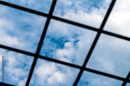metal grille against the blue sky and white clouds close-up
