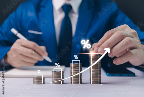 Businessman analyzing growth with coin stacks and percentage signs, conceptual financial success and investment. Planning long-term investments, buying DCA mutual funds, analyzing economic trends.