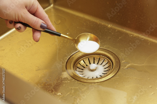 Billede på lærred Cleaning kitchen sink with bakIng soda to keep sinks draining well and prevent clogs
