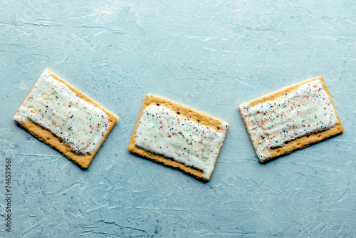 Pop tarts layout. Poptart toaster pastry with icing on a blue slate background, overhead flat lay shot with copy space photo