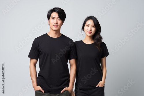Young asian couple in black t-shirt on gray wall background for clothing mockup