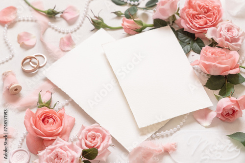 Blank cards near pink roses, engagement ring and silk ribbons close up, wedding mockup