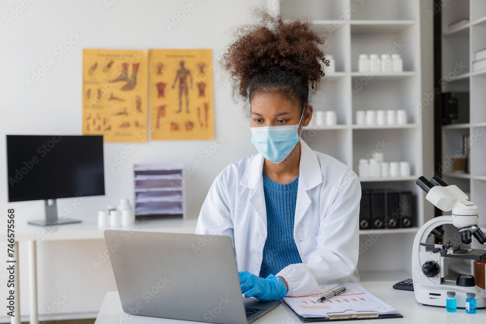Young African female researcher in medical science laboratory with microscope analysis while doing scientific research in the laboratory. Young African female researcher in medical science laboratory with microscope analysis while doing scientific research in the laboratory.