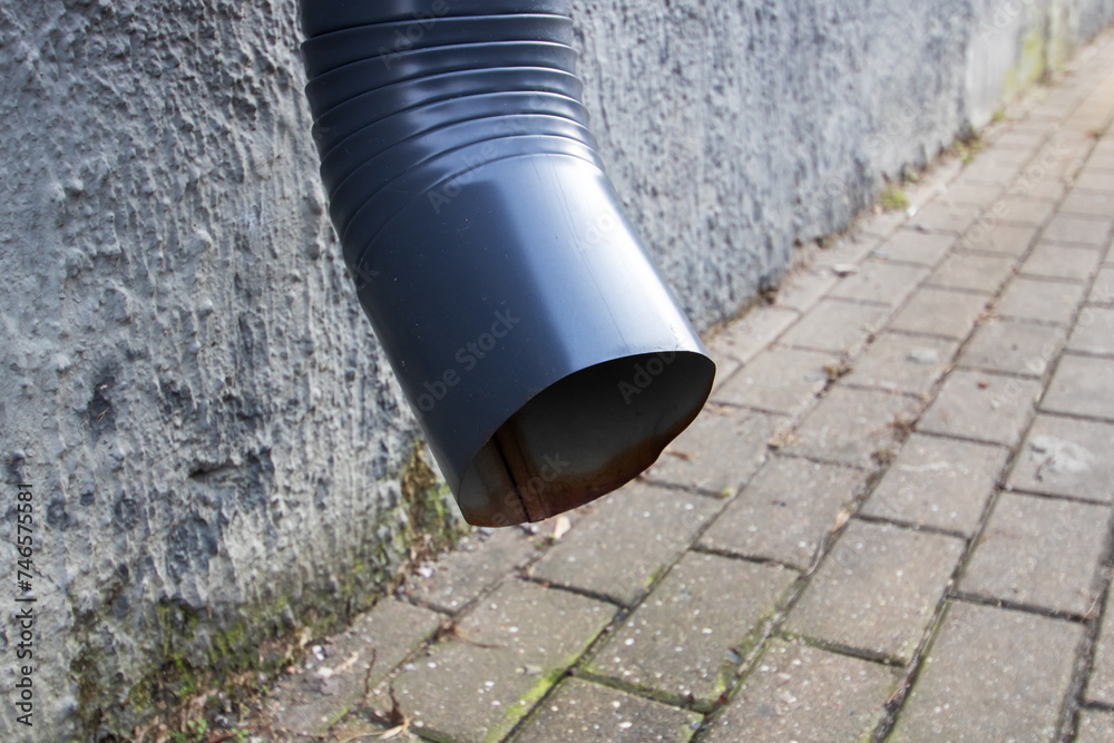Downspout on the wall above the pavement Downspout on the wall above the pavement