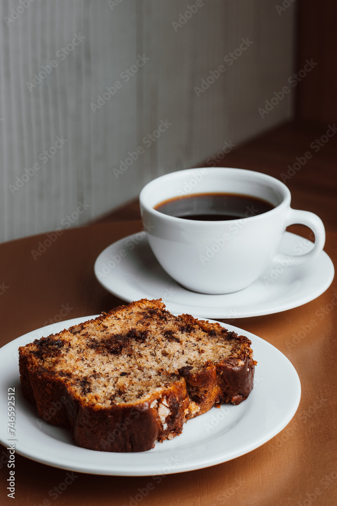 Piece of brown cake with coffee closeup Piece of brown cake with coffee closeup