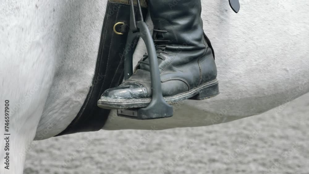 Legs close-up of a jockey sitting on a horse. Legs close-up of a jockey sitting on a horse.