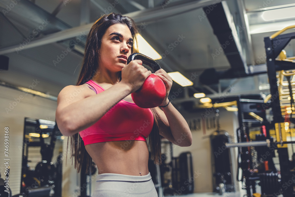 Shot of a woman working out with a kettle bell. Shot of a woman working out with a kettle bell.