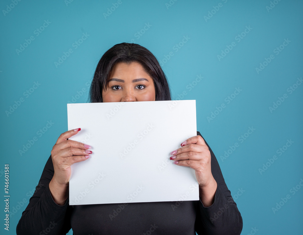 Plus sized hispanic woman holding a white sign with room for copy Plus sized hispanic woman holding a white sign with room for copy