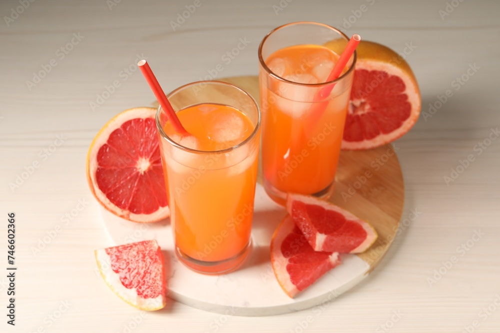 Tasty freshly made grapefruit juice and fruits on white wooden table Tasty freshly made grapefruit juice and fruits on white wooden table
