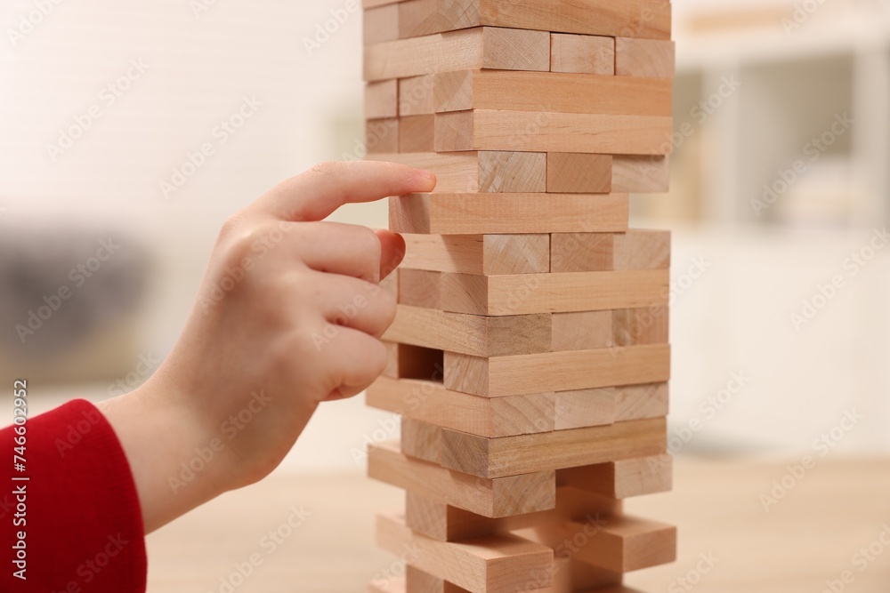 Child playing Jenga at table indoors, closeup Child playing Jenga at table indoors, closeup