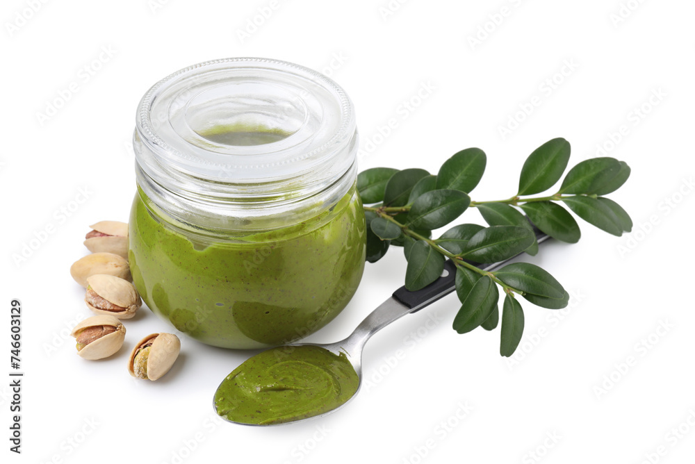 Tasty pistachio cream in jar, spoon, branch with leaves and nuts isolated on white Tasty pistachio cream in jar, spoon, branch with leaves and nuts isolated on white