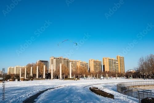 The frozen river surface and urban skyline in urban parks after snow #746610728