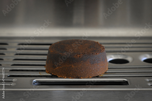 Dry coffee puck espresso puck on the tray of espresso machine