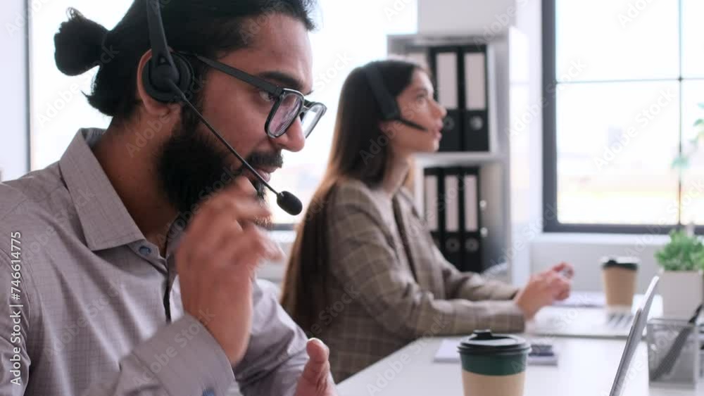 Portrait of an Indian call center agent using headset talking online, sitting at table in modern office. Help conversation, telecommunication concept. Portrait of an Indian call center agent using headset talking online, sitting at table in modern office. Help conversation, telecommunication concept.