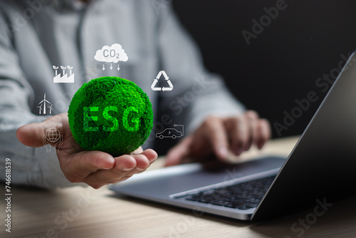 ESG,Environmental social and governance concepts, sustainable organizational development ,Businessman's hands hold green ESG icons to plan investment with environmentally friendly businesses