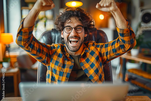 Excited happy man sitting in front of laptop, feeling like a winner, rejoicing at online victory, getting new job opportunity. Work from home, freelance photo