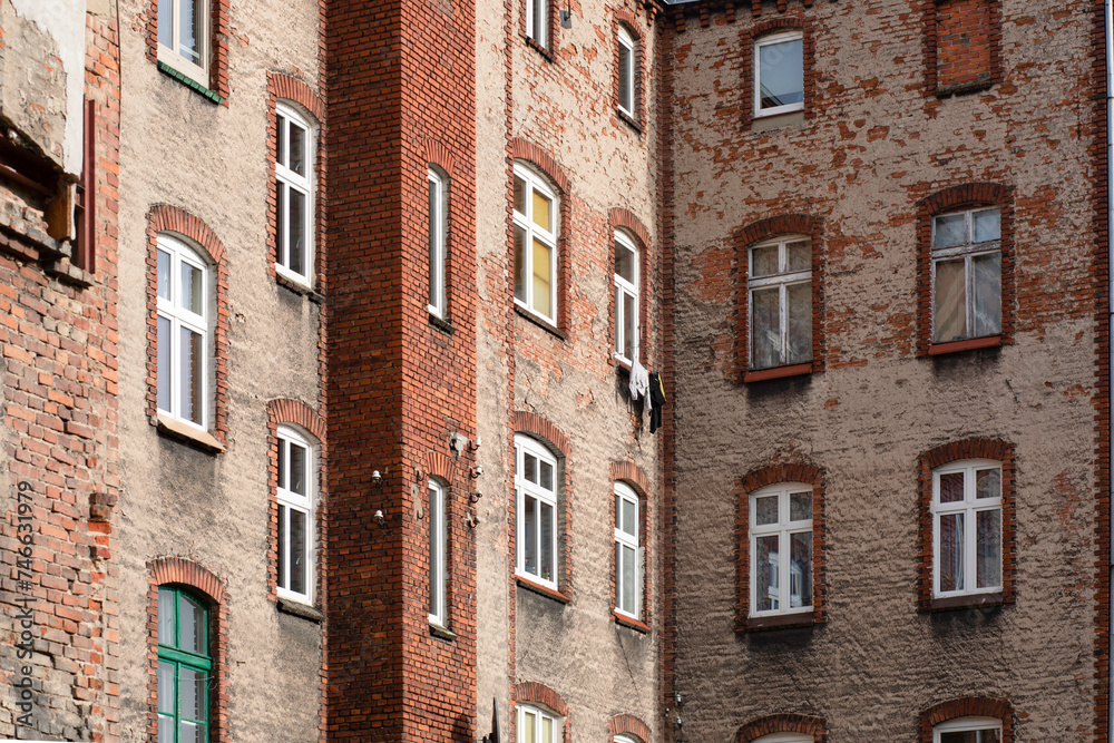 Windows in a red brick building, old building with falling plaster.