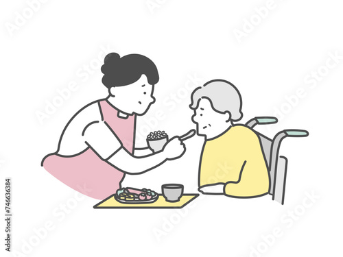 高齢女性の食事介助をする女性介護士