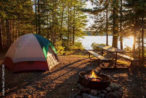 Campsite on lake in northern Minnesota with campfire at sunset