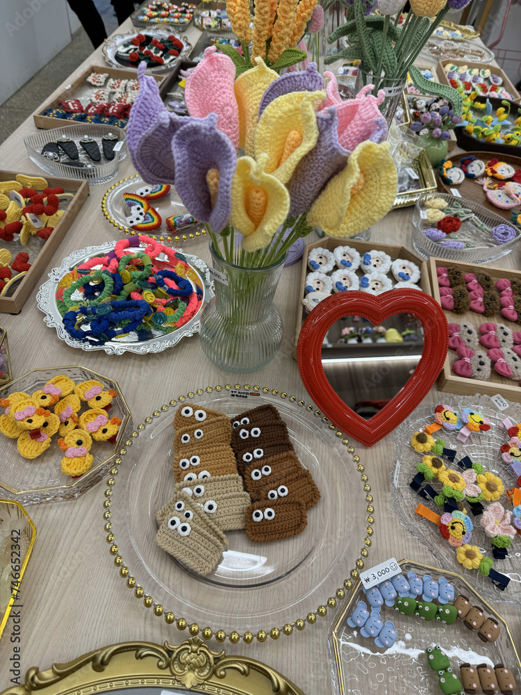A table filled with different shaped cookies in the form of flowers, blossoms, with eyes, etc. Sunday market. Raw social media photo
