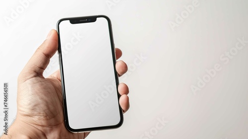 Hand of a white man holding a black mobile phone and a white screen at a wihite background