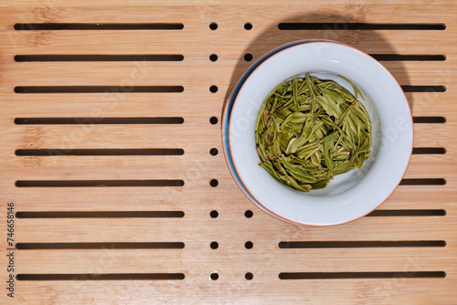 Brewed leaves of fresh green Chinese tea in a white bowl. Anji Bai Cha