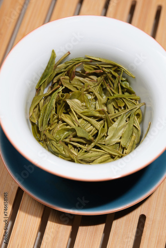 Brewed leaves of fresh green Chinese tea in a white bowl. Anji Bai Cha