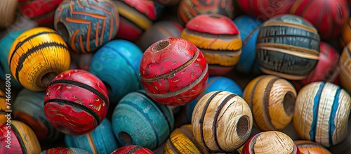 This close-up showcases several painted natural wood beads  revealing their intricate details and beauty up close. The intricate patterns and colors of the beads are highlighted in this artistic